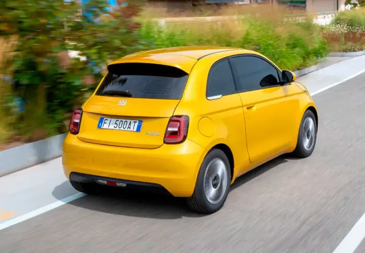 Un Fiat 500 Hybrid amarillo brillante en movimiento. ¡Una prueba de manejo emocionante!