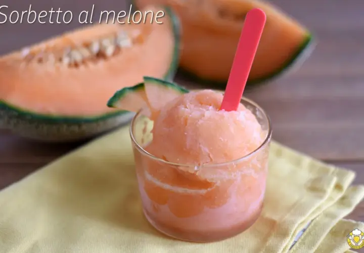 Sorbetto al melone rinfrescante in un bicchiere, con fette di melone fresco sullo sfondo.