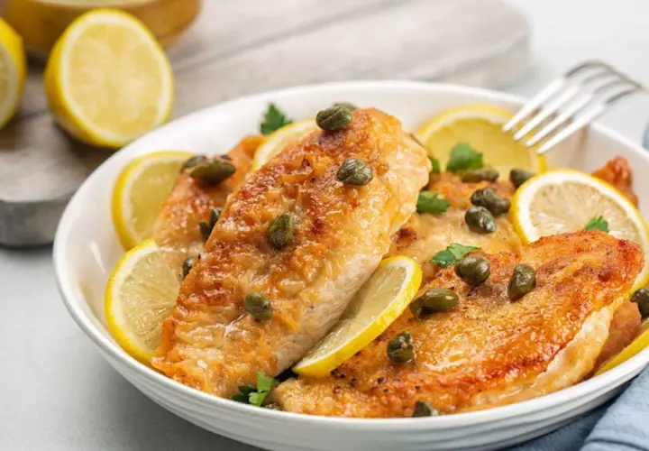Délicieux poulet au citron, garni de câpres et de rondelles de citron frais, prêt à être dégusté.