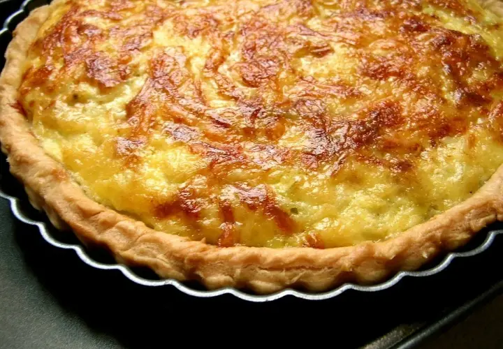 Une quiche aux poireaux dorée et appétissante, avec une croûte croustillante et une garniture crémeuse. Parfaite pour un repas réconfortant.