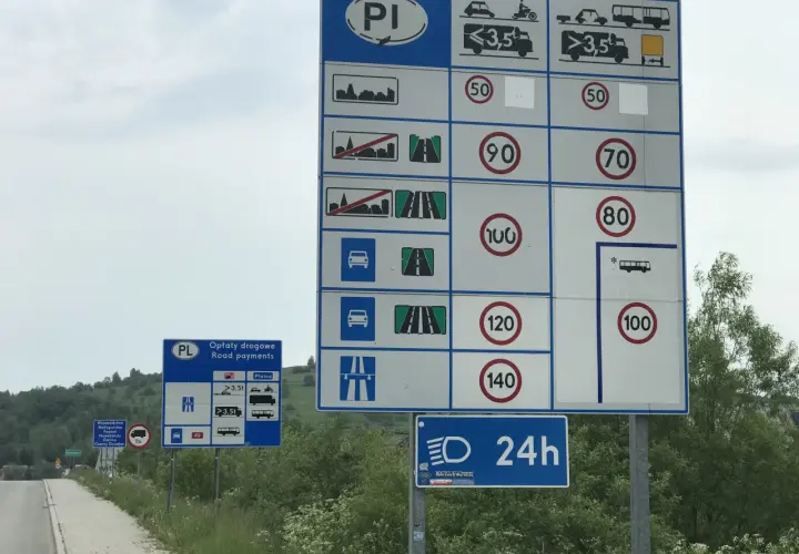 Znaki drogowe informujące o opłatach i ograniczeniach prędkości. Przygotuj się na jazdę w terenie zabudowanym i poza nim.