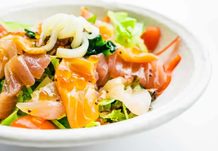 Deliziosa insalata di mare con verdure fresche, salmone affumicato, gamberi e uova di pesce, un tripudio di sapori e colori.