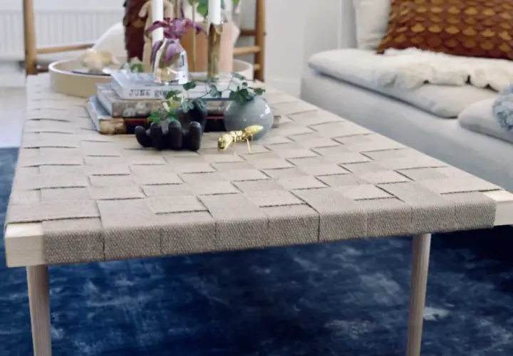 Ett vackert diy soffbord med flätad topp och träben. Prydnader som en guldfärgad myra och en liten vas ger liv åt bordet.