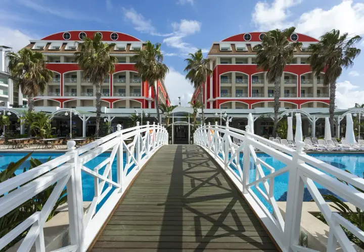 Mostek nad basenem prowadzi do hotelu w stylu Orange County w Belek.