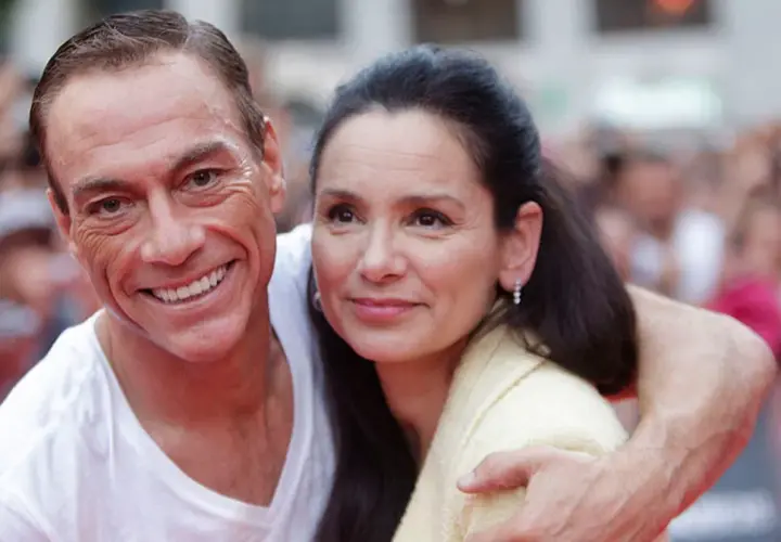 Jean-Claude Van Damme z żoną, uśmiechnięci, w tłumie.