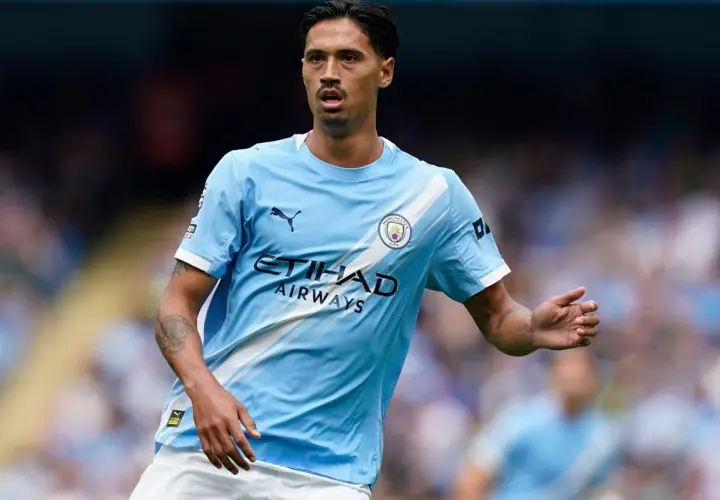 Piłkarz Manchester City w jasnoniebieskiej koszulce z logo klubu i napisem Etihad Airways.