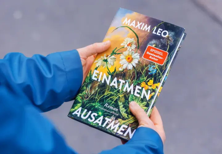 Hände halten das Buch "Einatmen Ausatmen" von SPIEGEL Bestseller-Autor Maxim Leo.