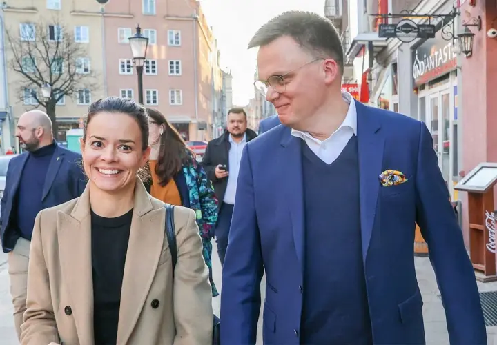Aleksandra z uśmiechem idzie ulicą, obok niej jej mąż.
