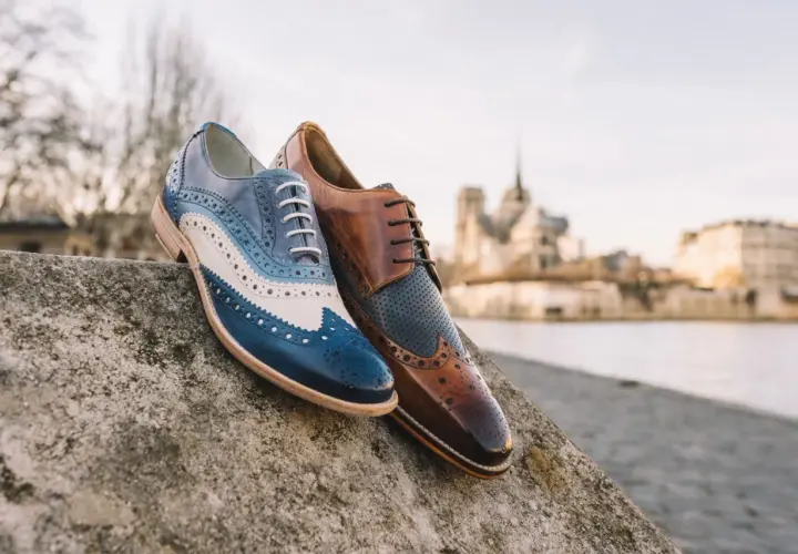 Eleganckie męskie buty derby, jeden w odcieniach niebieskiego i białego, drugi brązowy. Idealne na spacer po Paryżu.
