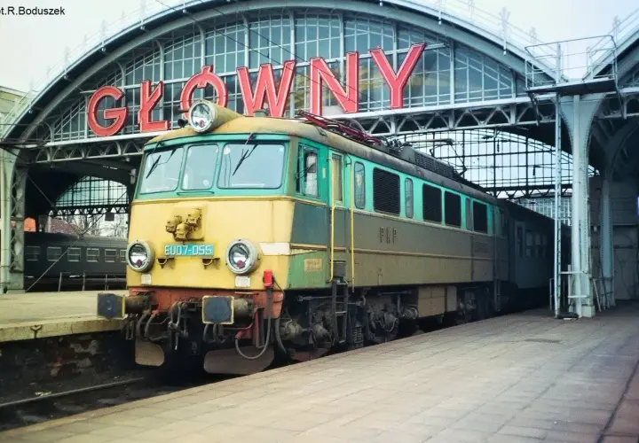 Lokomotywa EP07 na tle napisu "GŁÓWNY". Klasyk PKP gotowy do podróży.
