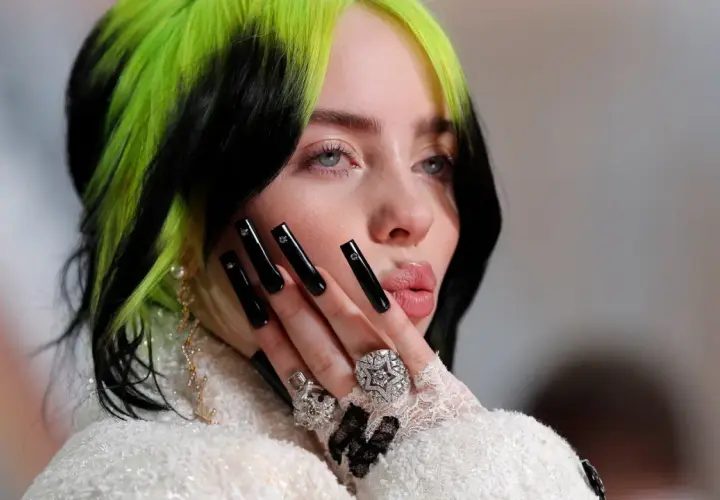 Billie Eilish z zielono-czarnymi włosami i długimi czarnymi paznokciami, przypominająca styl z piosenki "Nie czas umierać".
