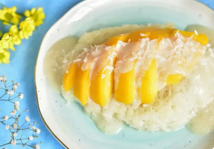 Słodki ryż kleisty z kawałkami mango i wiórkami kokosowymi, polany kremowym sosem. Pyszny deser mango sticky rice.