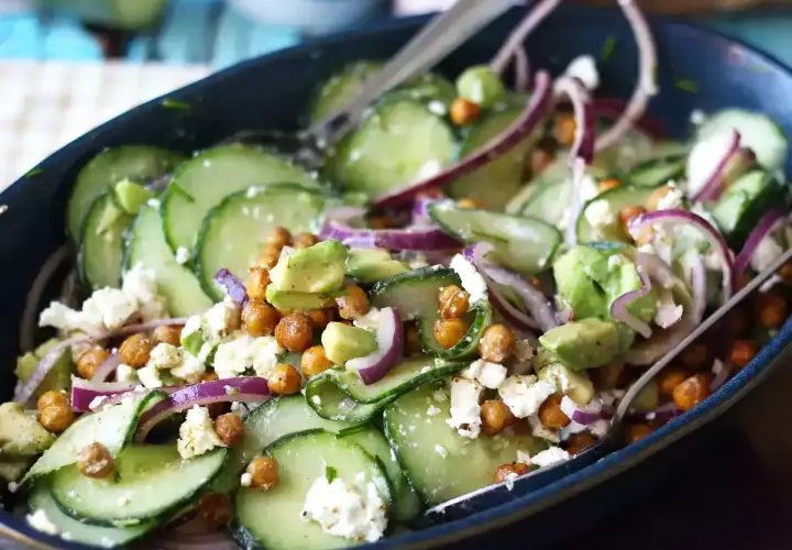 Deliziosa insalata di cetrioli con ceci croccanti, avocado cremoso, cipolla rossa e formaggio feta sbriciolato.