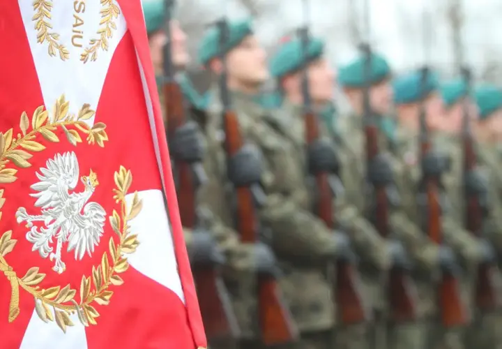 Orzeł biały na polskiej fladze i żołnierze w mundurach. Chcesz wiedzieć, jak dostać się do wojska?