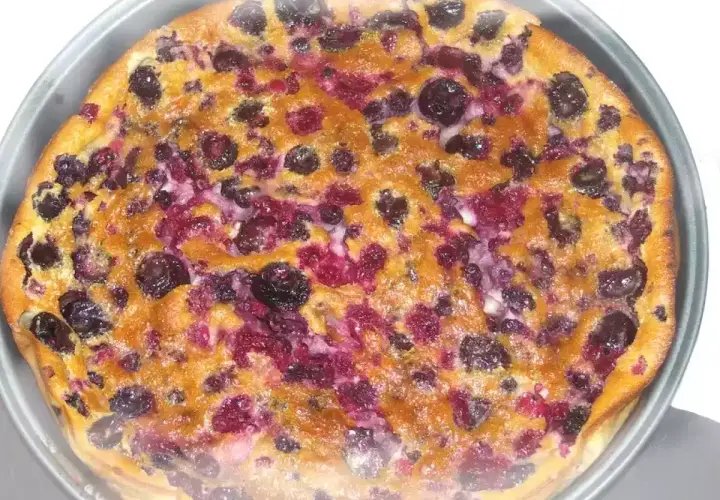 Un délicieux clafouti aux fruits rouges, tout juste sorti du four, avec ses myrtilles et framboises fondantes.