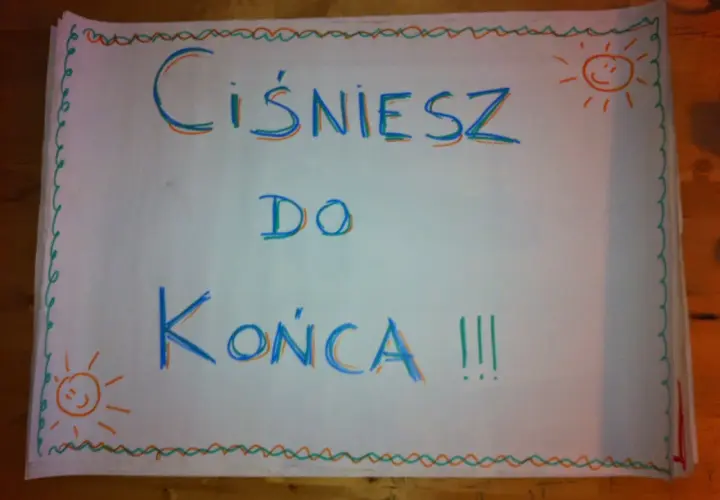 Hasła dopingujące biegaczy: "Ciśniesz do końca !!!" z uśmiechniętymi słoneczkami po bokach.