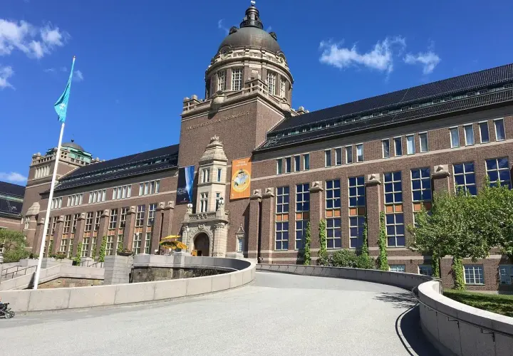 Imponerande byggnad för Naturhistoriska riksmuseet i Stockholm. En blå flagga vajar stolt.