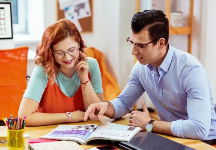 Ragazza e ragazzo studiano insieme, lui indica qualcosa sul libro. Ci sono molte frasi interessanti da scoprire.