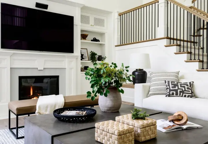 Stylish coffee table decor ideas: woven boxes, a black tray with a magazine, and a large vase with greenery.