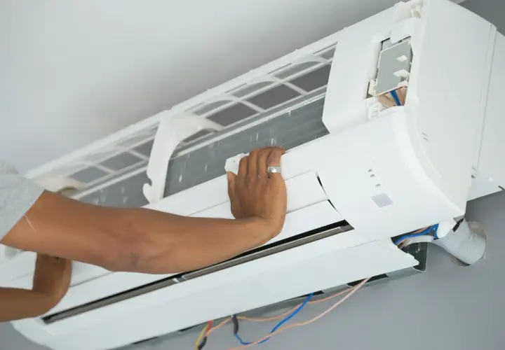 Mano ajustando el cepillo para limpiar la turbina del aire acondicionado.