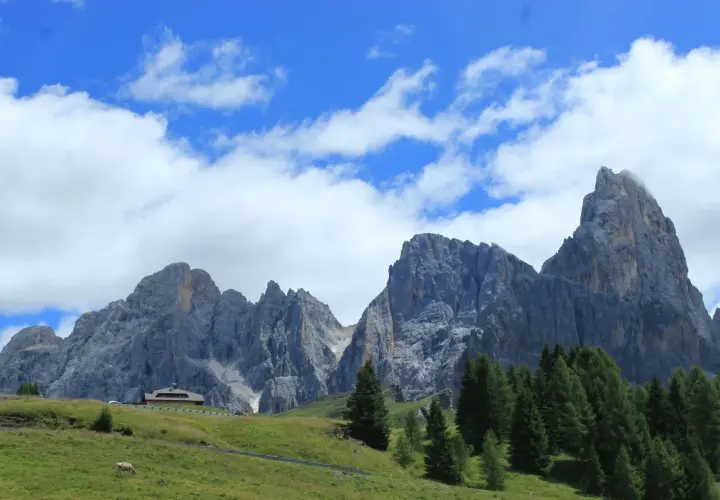 Majestuosas montañas de los Picos de Europa, un paisaje ideal para recorrer con tu camper. Nubes blancas adornan el cielo azul.