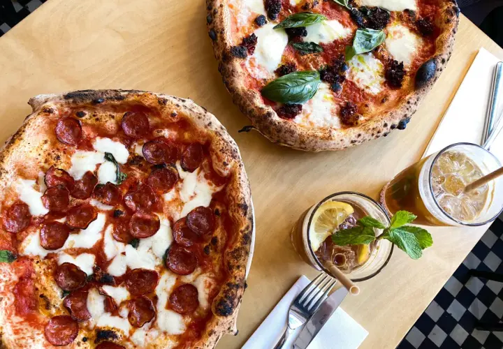 Dwie pyszne pizze, jedna z salami, druga z pomidorami i mozzarellą, idealne na najlepszą pizzę Warszawa. Do tego orzeźwiające napoje.