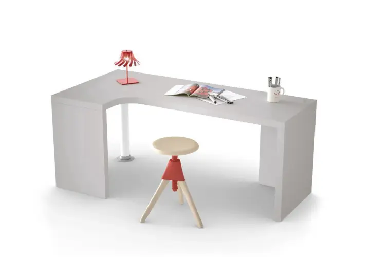 Scrivania in cartongesso angolare con sgabello, lampada rossa e tazza sorridente.