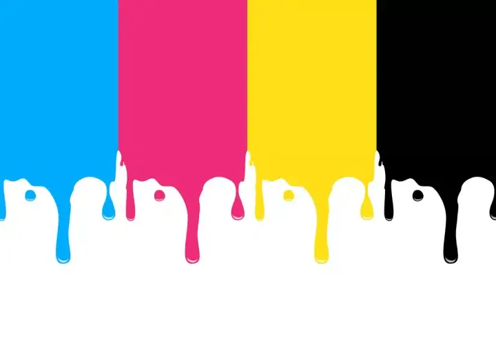 Krople farby CMYK (cyjan, magenta, żółty, czarny) spływające z góry na białe tło.