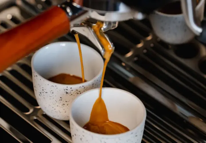 Espresso fließt in zwei Tassen. Hoffentlich ist der Kaffee zu sauer, sonst ist er perfekt.