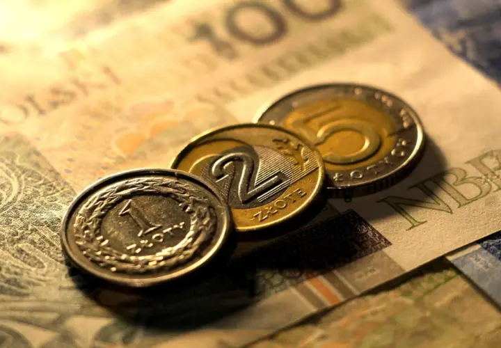 Monety 1, 2 i 5 złotych na tle banknotu 100 zł. Zastanawiasz się, przedterminowy wykup obligacji ile trwa?