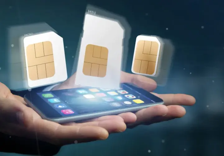 Dłoń trzyma smartfon, nad którym unoszą się karty SIM różnych rozmiarów, symbolizujące aktywację karty SIM i wybór odpowiedniego formatu.