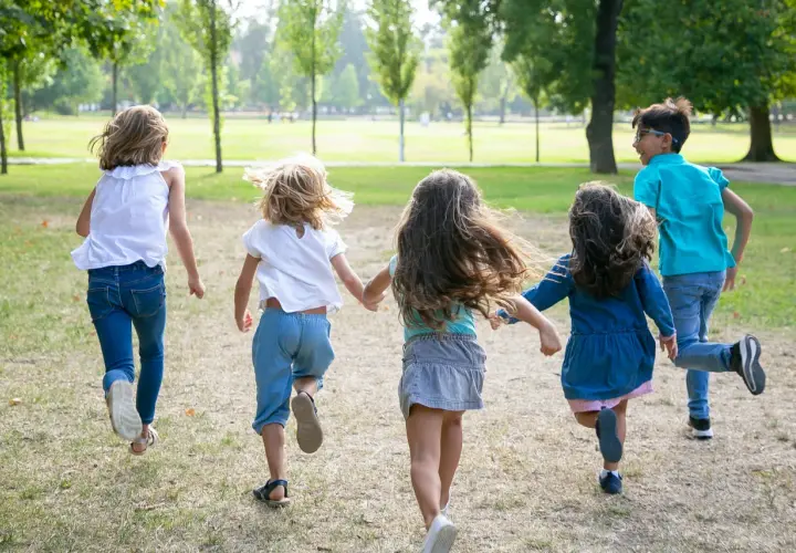 Niños corriendo en un parque, disfrutando de la **infantil primavera**.