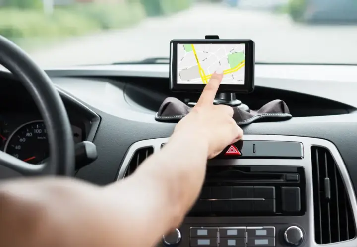 Ręka dotyka ekranu nawigacji, pomagając wybrać najlepszy gps do samochodu.