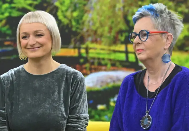 Dwie kobiety, jedna z krótkimi blond włosami, druga z siwymi z niebieskimi pasemkami, rozmawiają. Może facet 30 lat bez dziewczyny szuka rady u przyjaciółki?