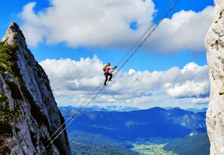 Wspinaczka po moście linowym na via ferrata w Niemczech. Widok zapiera dech w piersiach, a dolina rozciąga się w oddali.