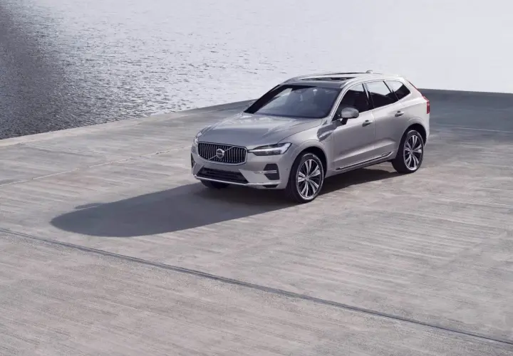 Srebrne Volvo XC60 na betonowym placu przy wodzie. Zwróć uwagę na rozmiar opon, idealnie dopasowany do SUV-a.