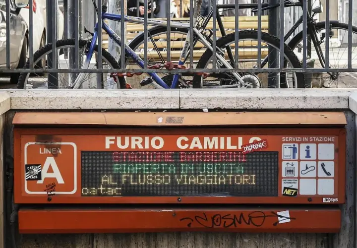 Segnale luminoso alla fermata Furio Camillo, Linea A. Biciclette parcheggiate dietro una ringhiera.