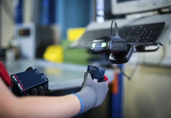 Hände mit Handschuhen halten Topran-Verpackungen unter einem Scanner. Gute Topran Erfahrungen im Lager.