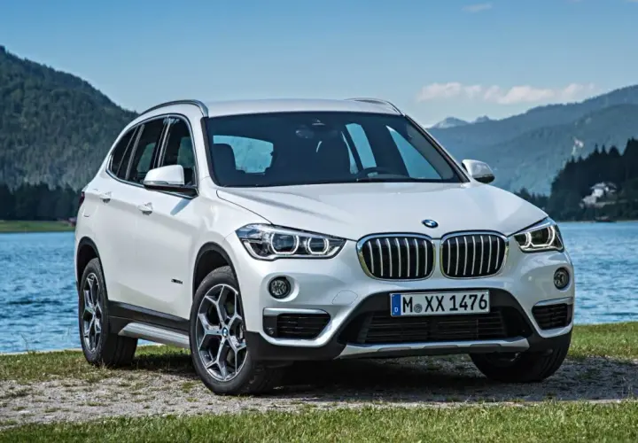BMW X1 blanco aparcado junto a un lago. Opiniones sobre el mantenimiento de este modelo son positivas.