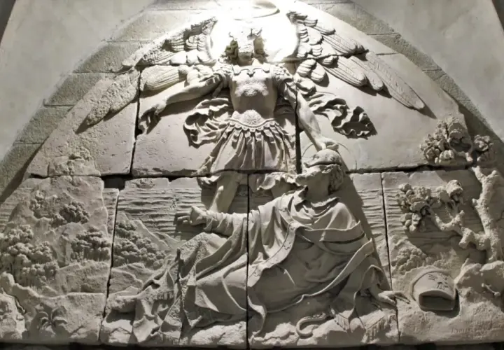 Relief mit Erzengel Michael, der einen Mann vor einem Drachen rettet. Die Szene zeigt die Namen der Erzengel in der Darstellung.