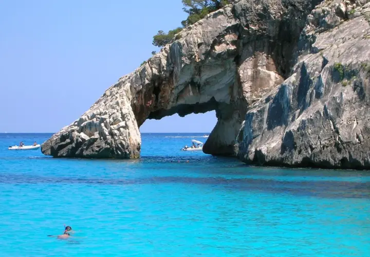 Arco naturale su mare cristallino, un paradiso tra i posti più belli del mondo mare. Barche e sub esplorano le acque turchesi.