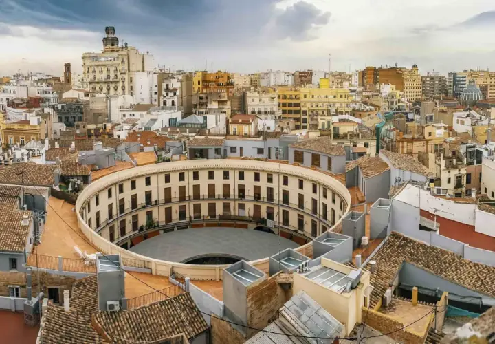 Vista aérea de Valencia, con la plaza de toros circular en primer plano. Imagina tomar el tren de Alicante a Valencia y llegar a esta maravilla.