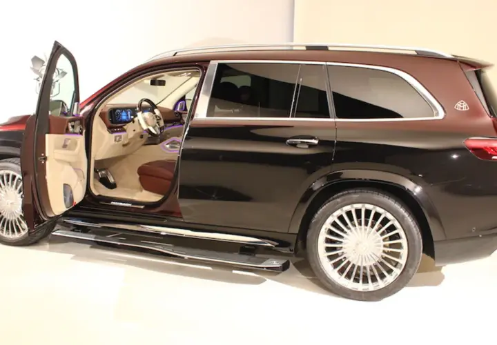 Mercedes-Maybach GLS z otwartymi drzwiami, widoczne luksusowe wnętrze i dwukolorowe nadwozie.