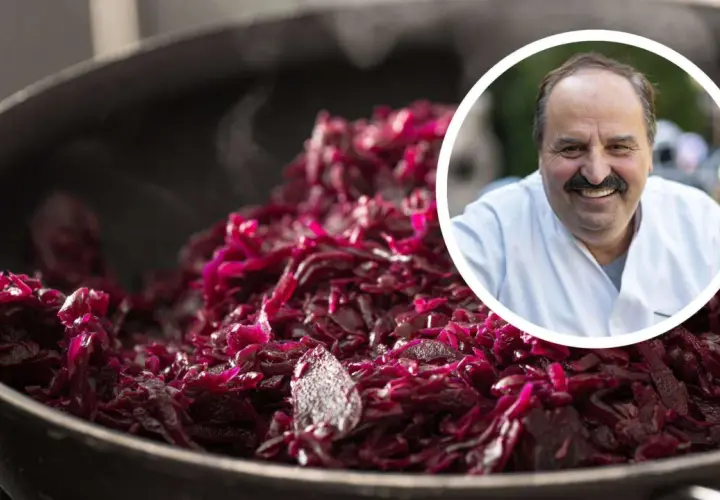 Ein Koch lächelt, während er dampfendes Blaukraut verfeinert.