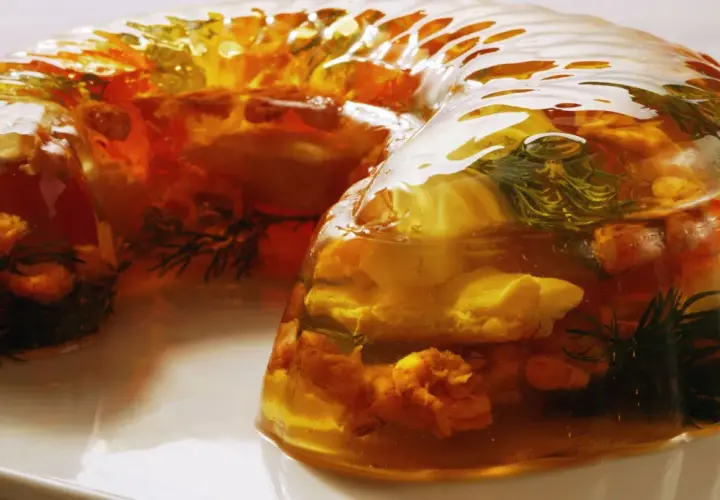 Wykwintny filet z karpia w galarecie, z dodatkiem ziół i warzyw, prezentuje się apetycznie.