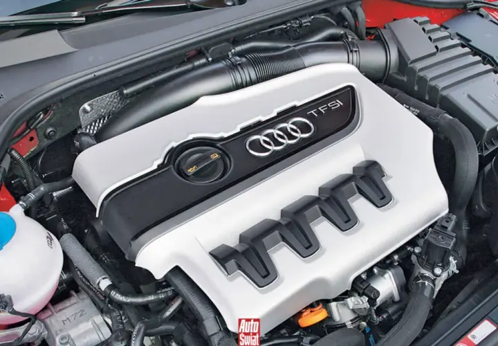 Silnik 2.0 TFSI z Audi A5, gotowy do pracy. Widoczna pokrywa silnika z logo Audi i oznaczeniem TFSI.