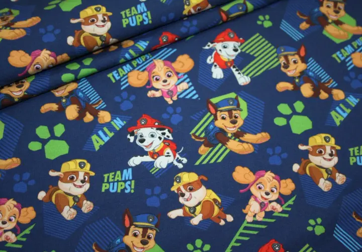 Materiał Psi Patrol z wesołymi pieskami i hasłem "TEAM PUPS!". Idealny dla małych fanów przygód.