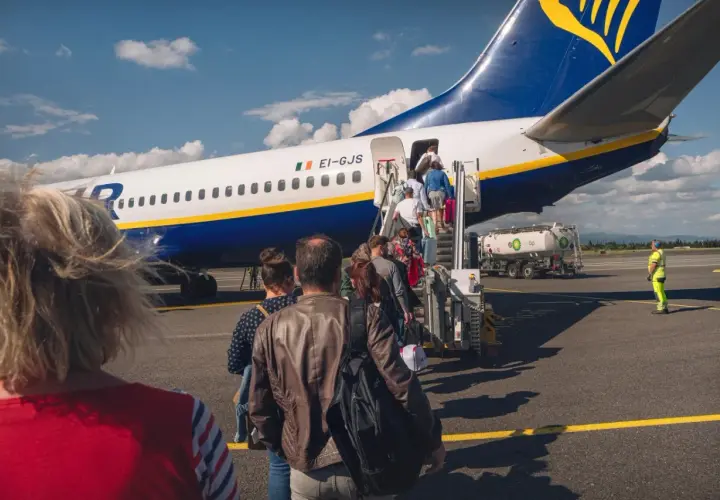 Ludzie wchodzą po schodkach do samolotu Ryanair. Czas na odprawę!