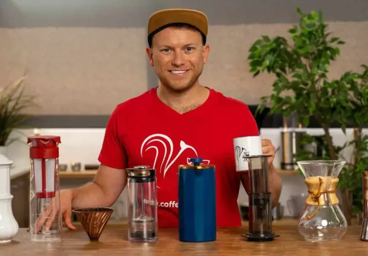 Mann mit verschiedenen Kaffeebereitern, die zeigen, welche Kaffeezubereitung die beste ist.