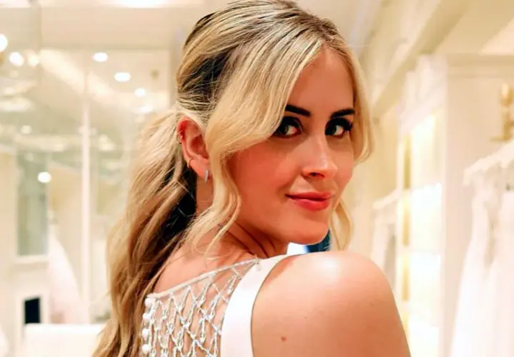 Valentina Ferragni sonríe con un vestido blanco de tirantes y detalles de perlas, en una tienda de novias.